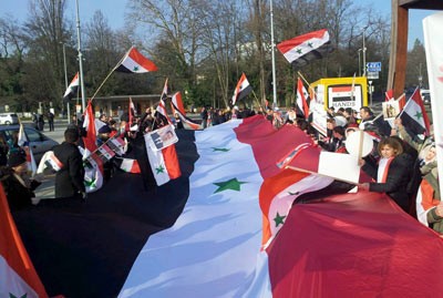 مئات السوريين والعرب يتجمعون أمام مقر الأمم المتحدة في جنيف دعما لوطنهم وجيشهم ورفضا للإرهاب